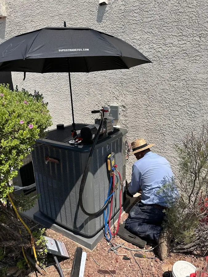 HVAC technician performing outdoor AC maintenance in Charles City