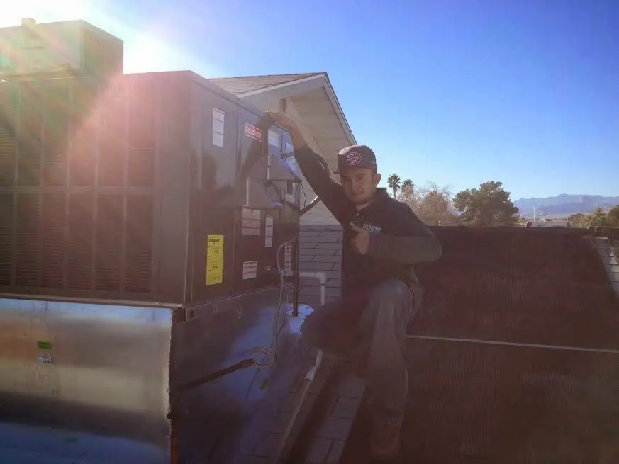 HVAC technician performing HVAC Inspection on a rooftop unit in Charles City